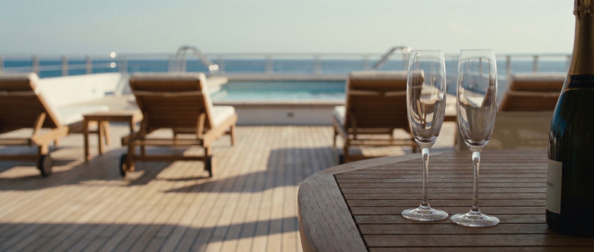 Cruise ship pool deck at sunset with empty deck chairs